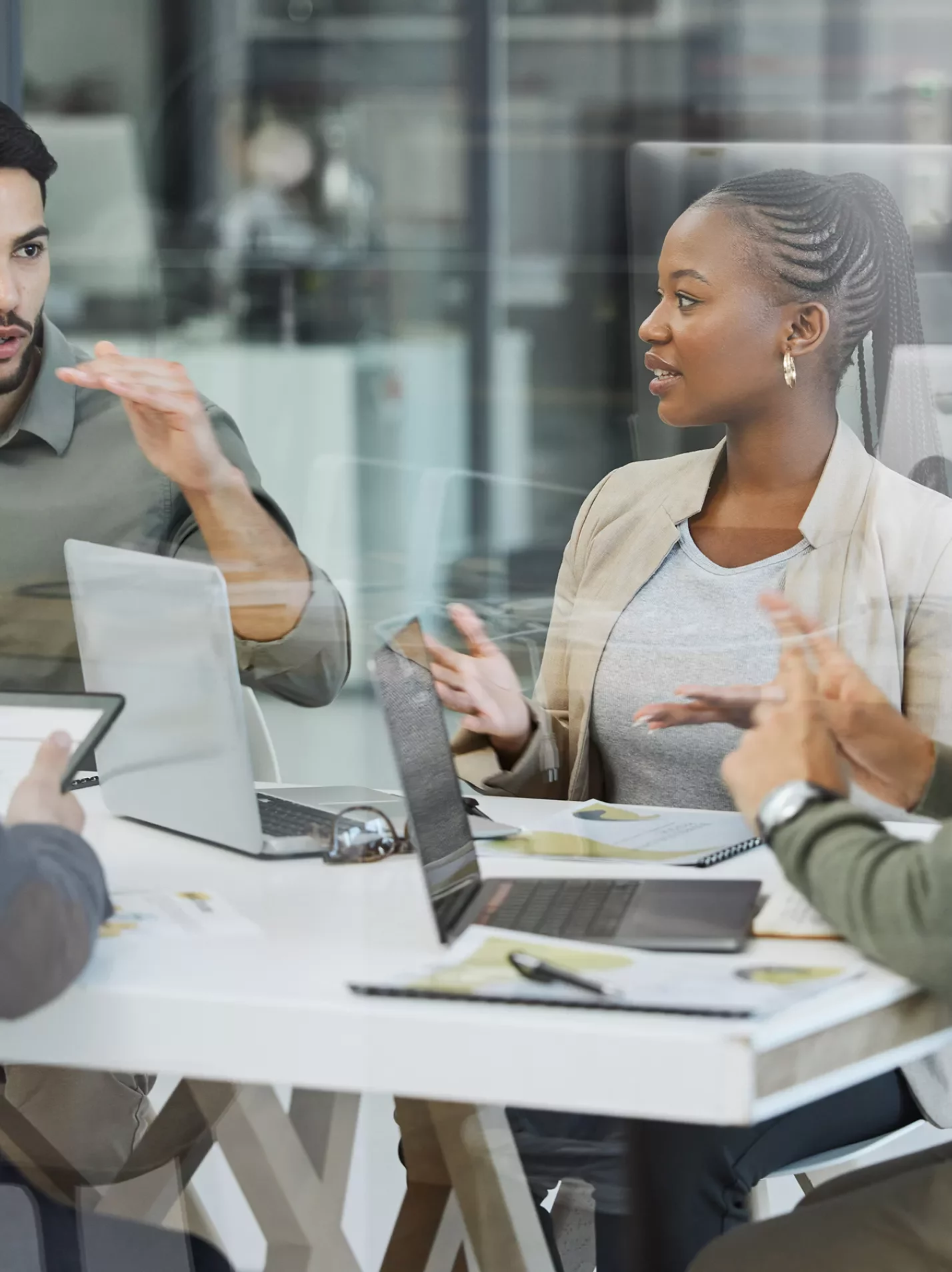 Business people meeting around a conference table with a laptop in conversation