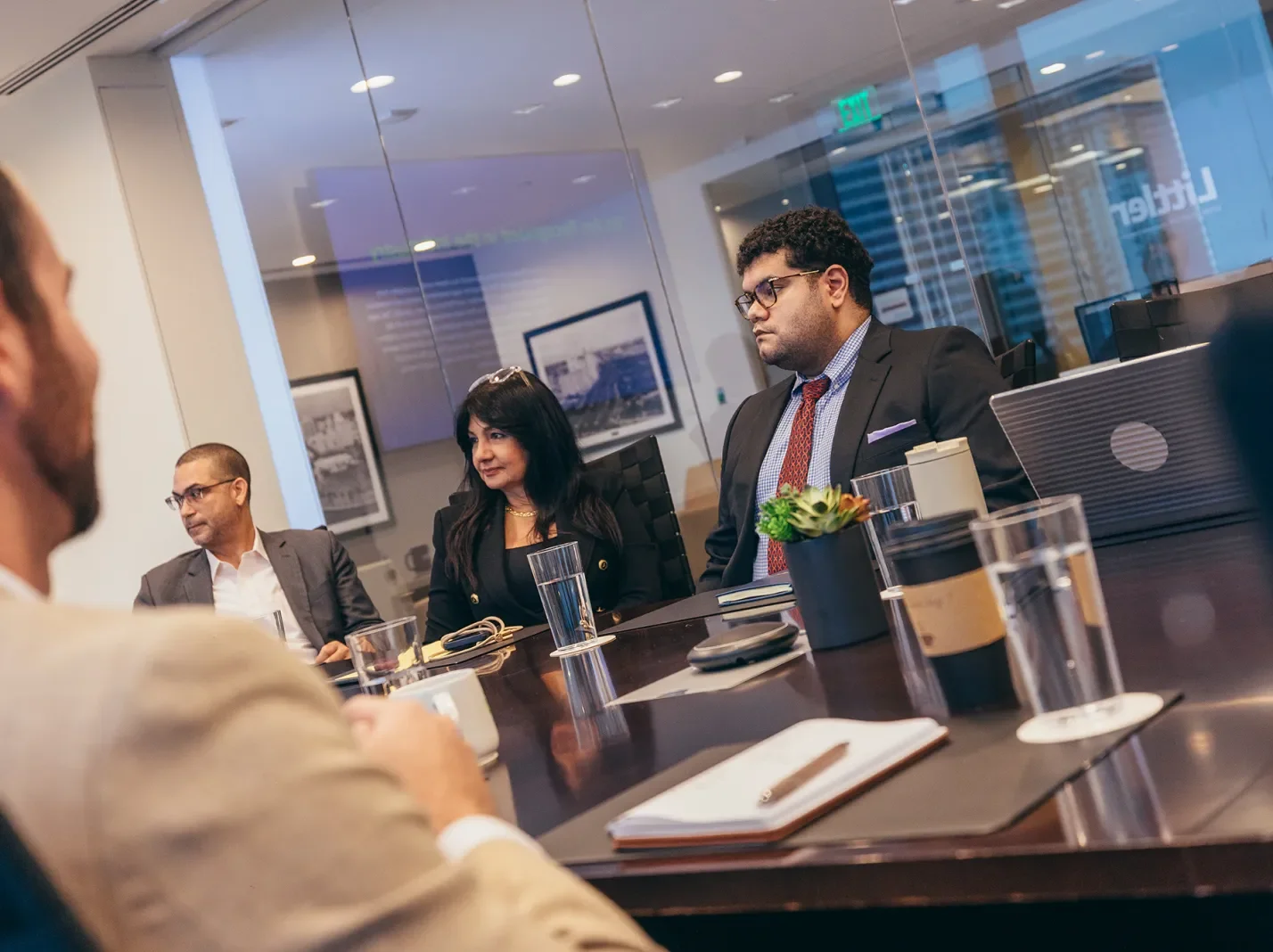 People in suits at a conference table in a Littler office