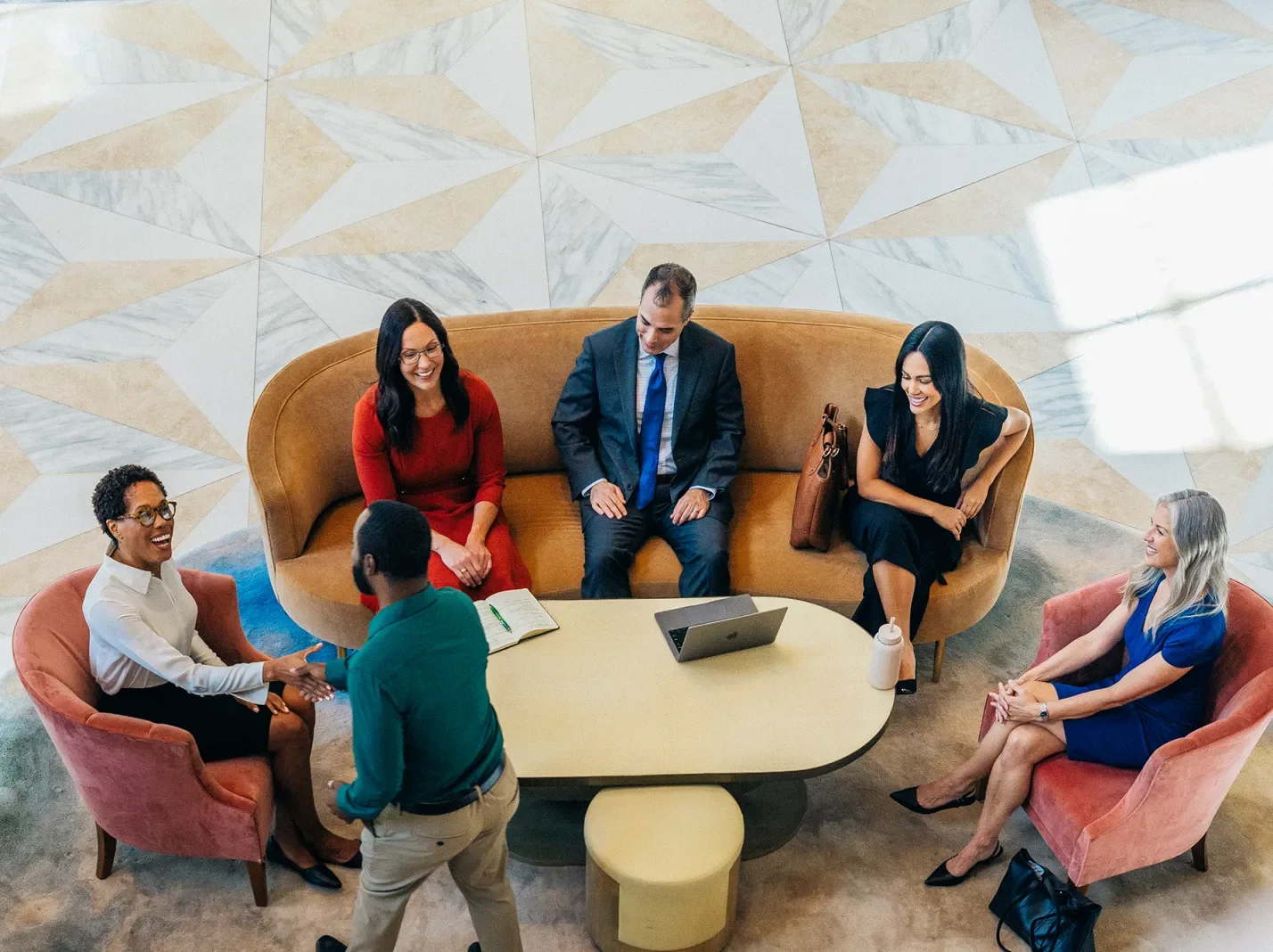Overhead view of business people in a lobby meeting around a table