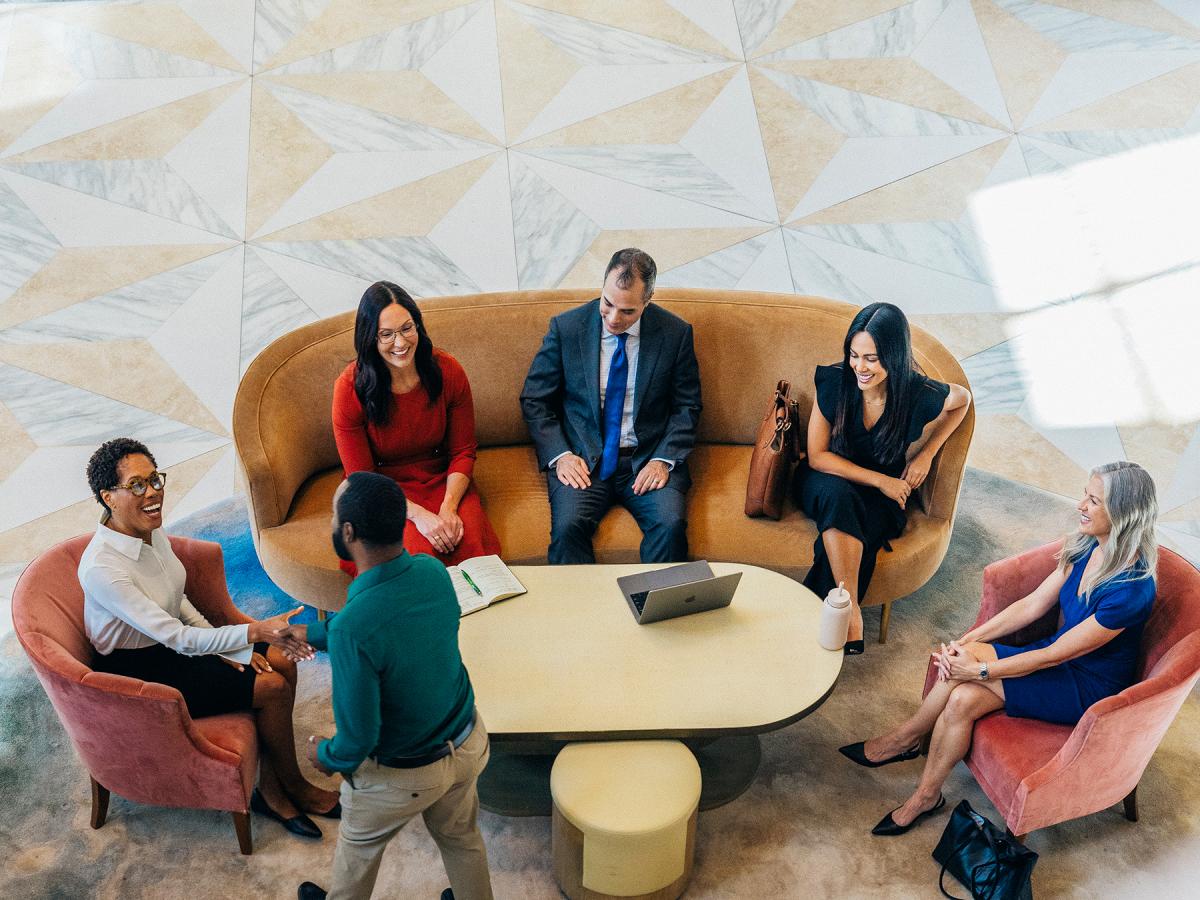 Overhead view of business people in a lobby meeting around a table