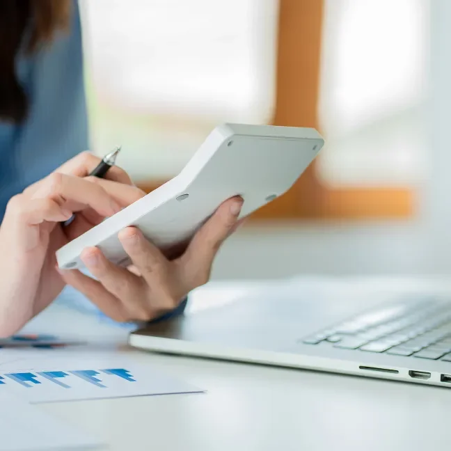 Hands holding a calculator auditing