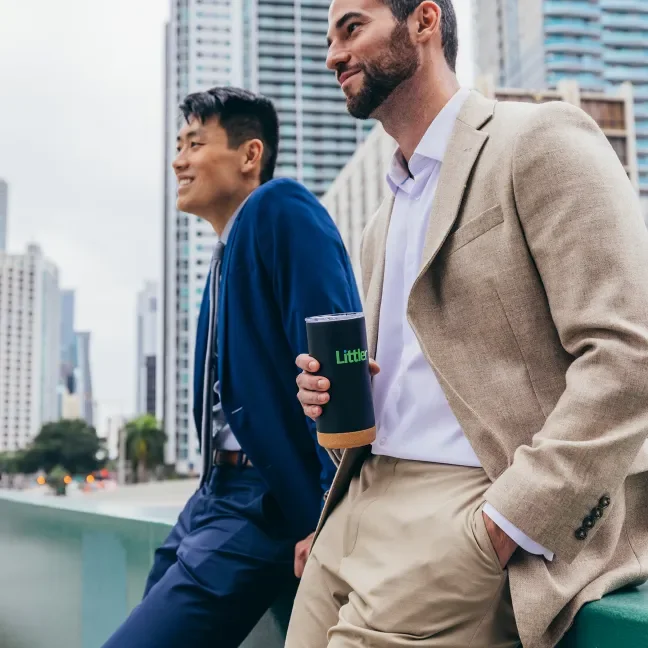 Two men in suits outside tall office buildings